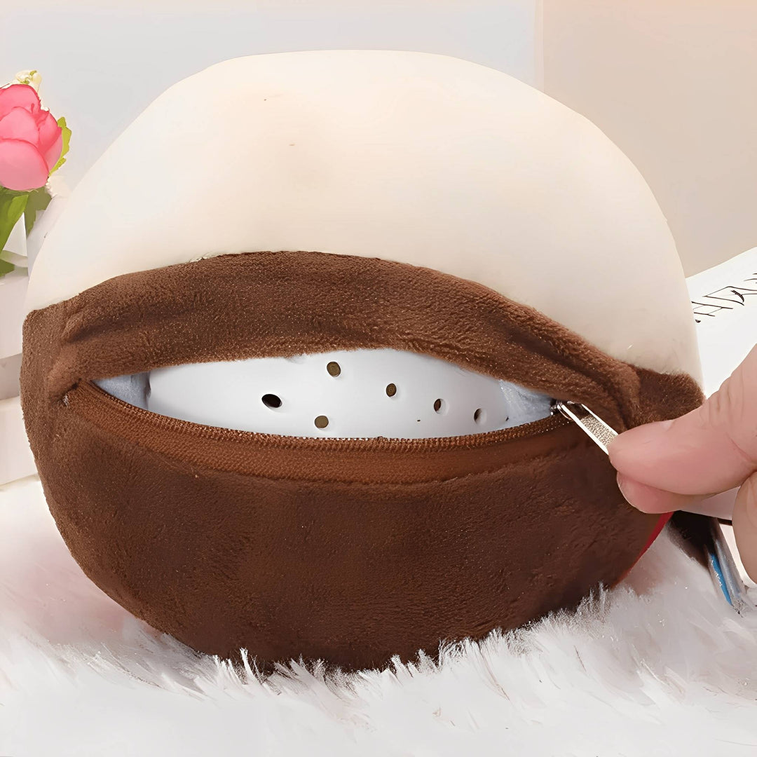 Gros plan sur la fermeture éclair ouverte de la balle en peluche, laissant voir la boule intérieure blanche perforée, tenue par une main. 6