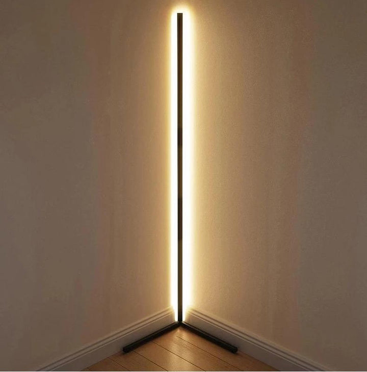 Lampadaire noir posé dans l'angle de deux murs, lumière blanc chaud sur toute la hauteur 12