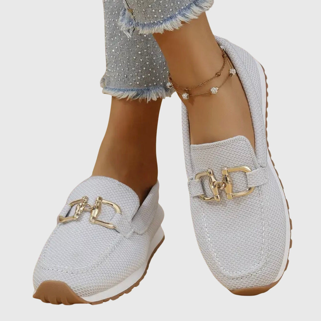 Gros plan sur les mocassins gris clair portés, détail de la boucle dorée 9