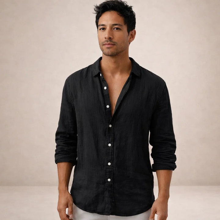 Homme portant la chemise en lin noire, vue de face, col ouvert, manches retroussées, boutons blancs contrastants. 10