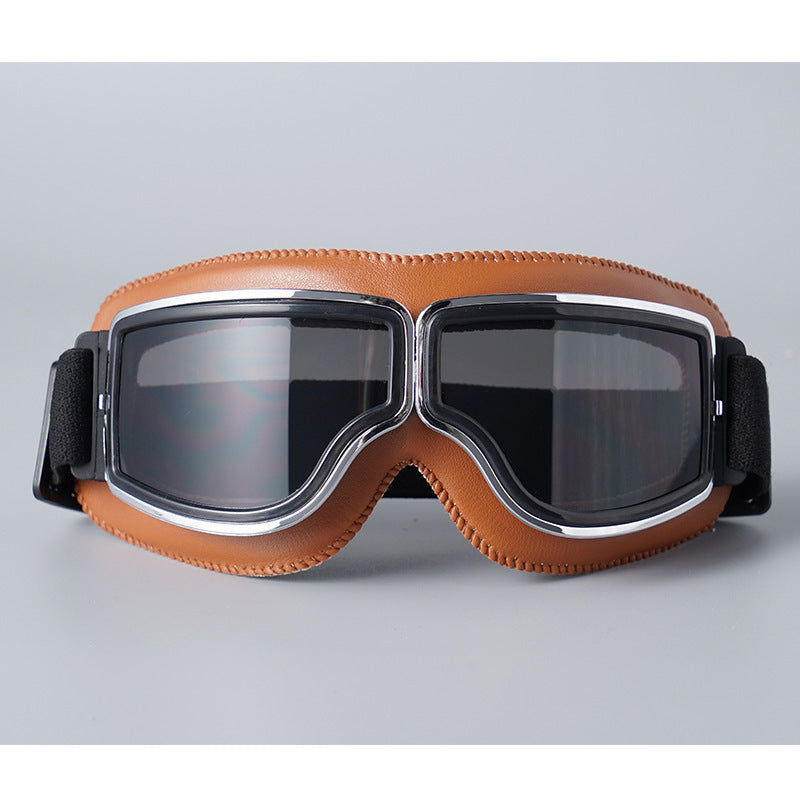 Lunettes à contour marron clair surpiqué avec verres fumés gris, monture chromée et sangle élastique noire. 8