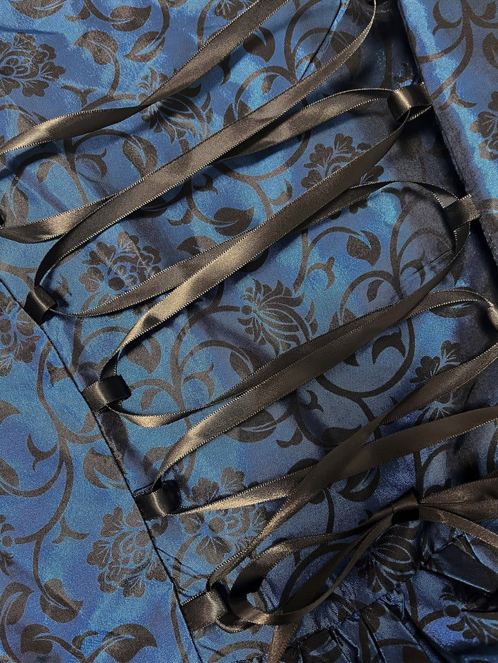 Gros plan sur le laçage en ruban noir satiné sur le tissu bleu à motifs floraux noirs. 5