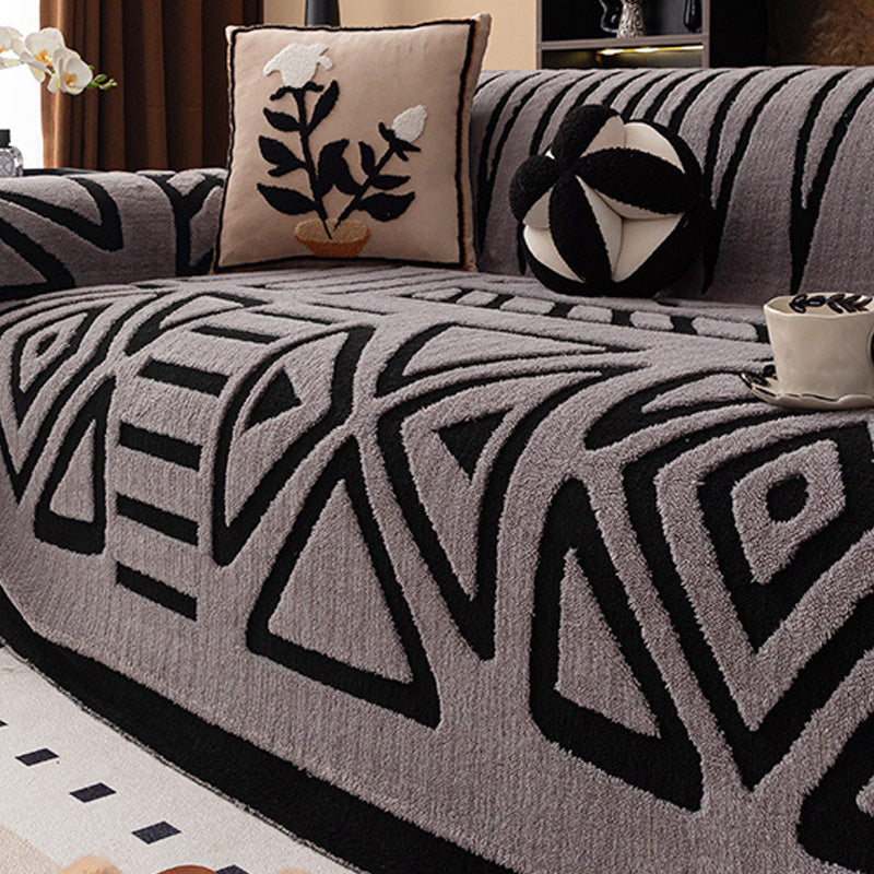 Housse grise à motifs géométriques noirs en triangles et losanges, avec coussin à fleur brodée 15
