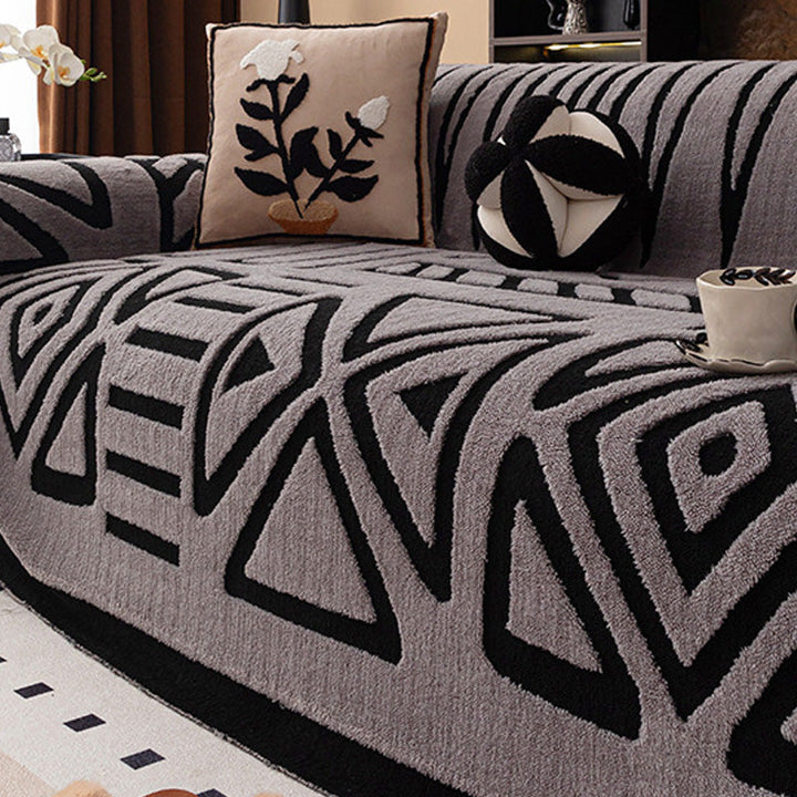 Housse grise à motifs géométriques noirs en triangles et losanges, avec coussin à fleur brodée 15