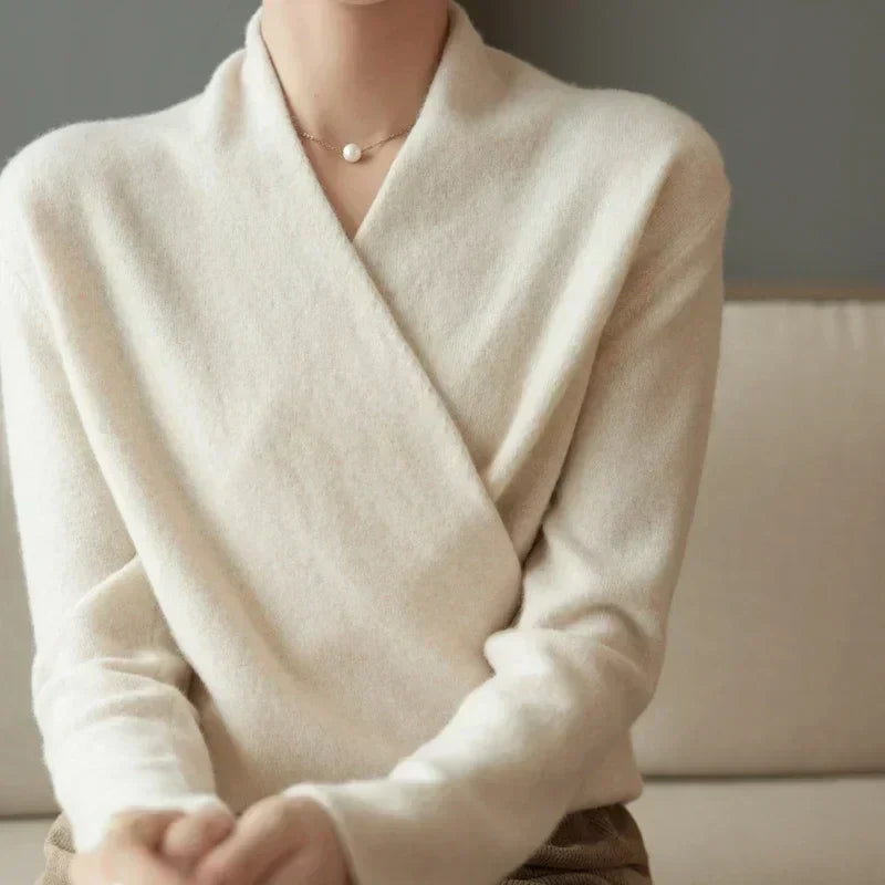 Vue rapprochée du devant croisé du pull écru, doux et duveteux, avec un collier de perle 15