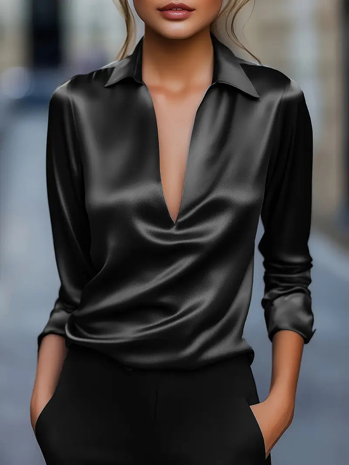 Version noire au satin brillant portée avec un pantalon noir, manches longues retroussées et col rabattu. 4