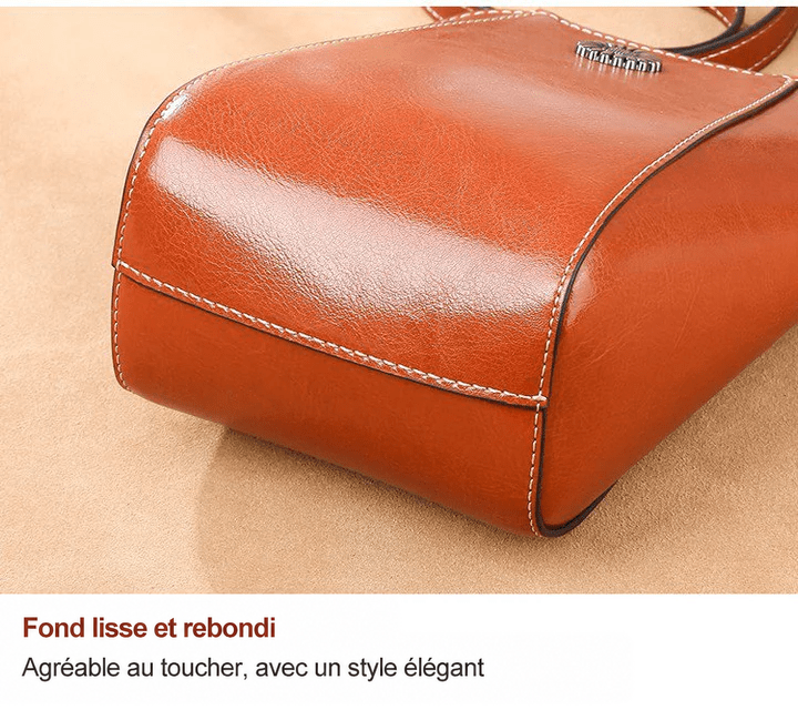 Gros plan sur le fond arrondi et lisse du sac en cuir brun roux, avec ses coutures 11