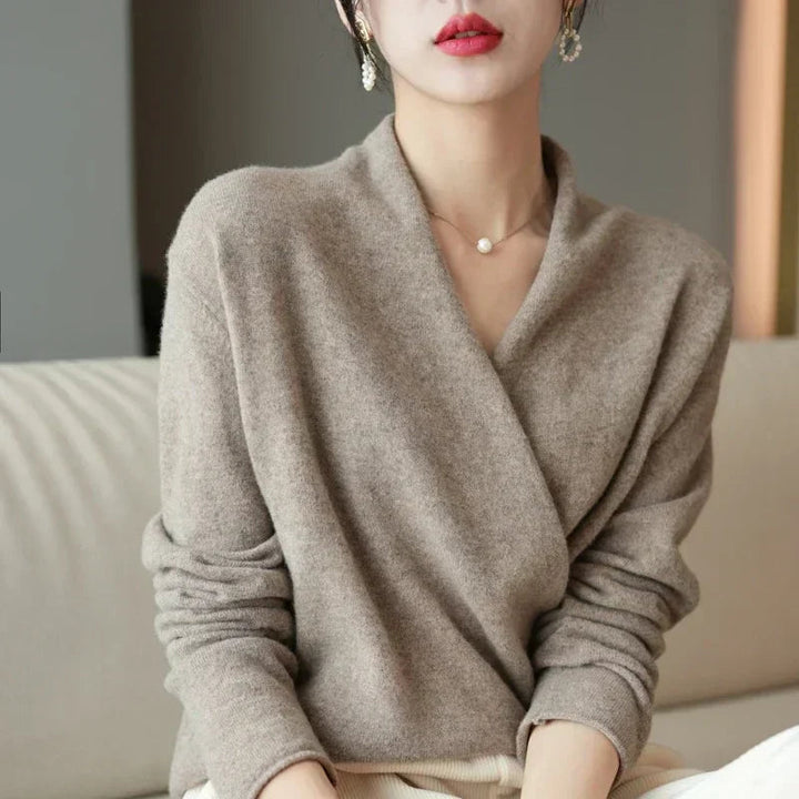 Pull croisé beige taupe vu de face, porté assise sur un canapé clair 13