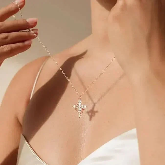 Gros plan portÃ© sur une femme en dÃ©bardeur blanc, croix sertie de pierres suspendue Ã  une fine chaÃ®ne dorÃ©e. 3