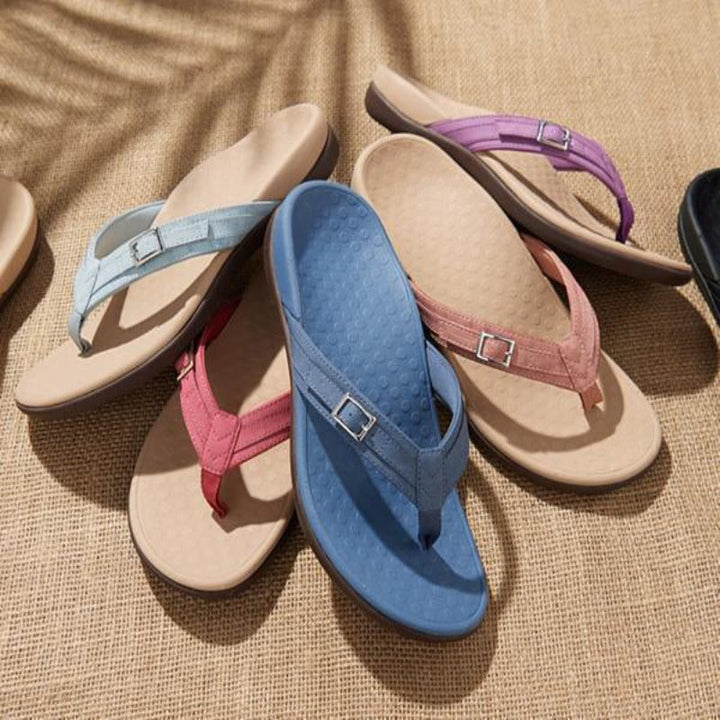 Tongs de plusieurs coloris (bleu, rose, violet, bleu clair) disposées sur un tissu naturel 11