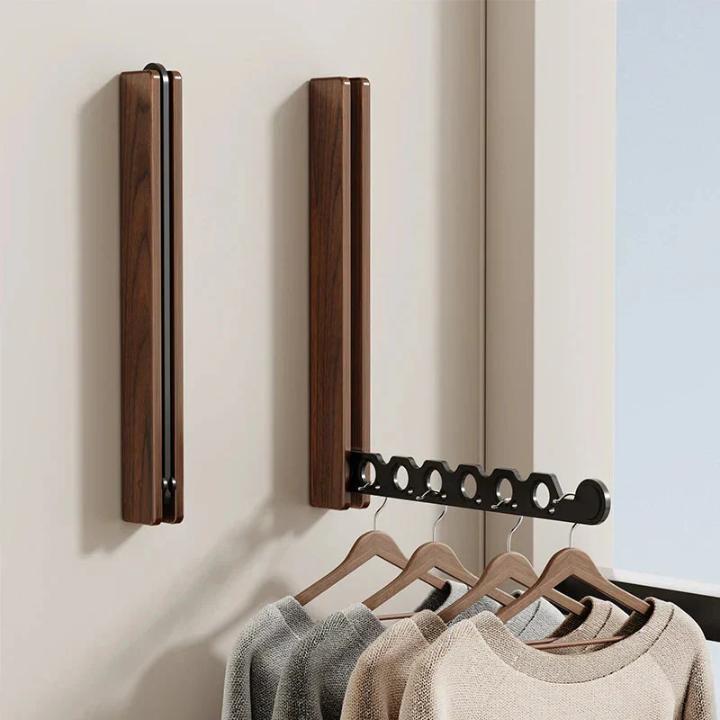 Deux supports en bois foncé, l'un replié, l'autre déplié avec cintres en bois et pulls suspendus. 7