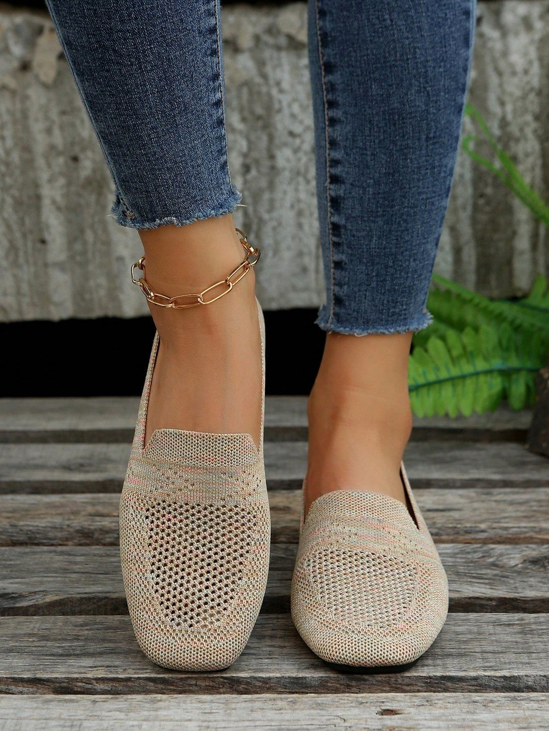 Paire beige en maille ajourée portée de face avec un jean, empiècement en V et fond de bois. 3