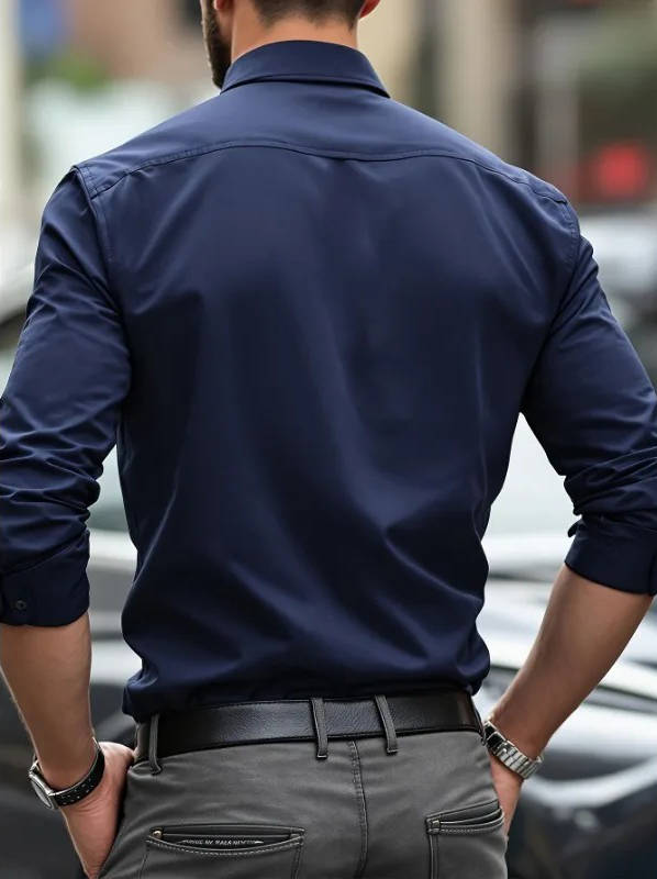 Vue de dos de la chemise bleu marine portée par un homme, manches retroussées, pantalon gris 10