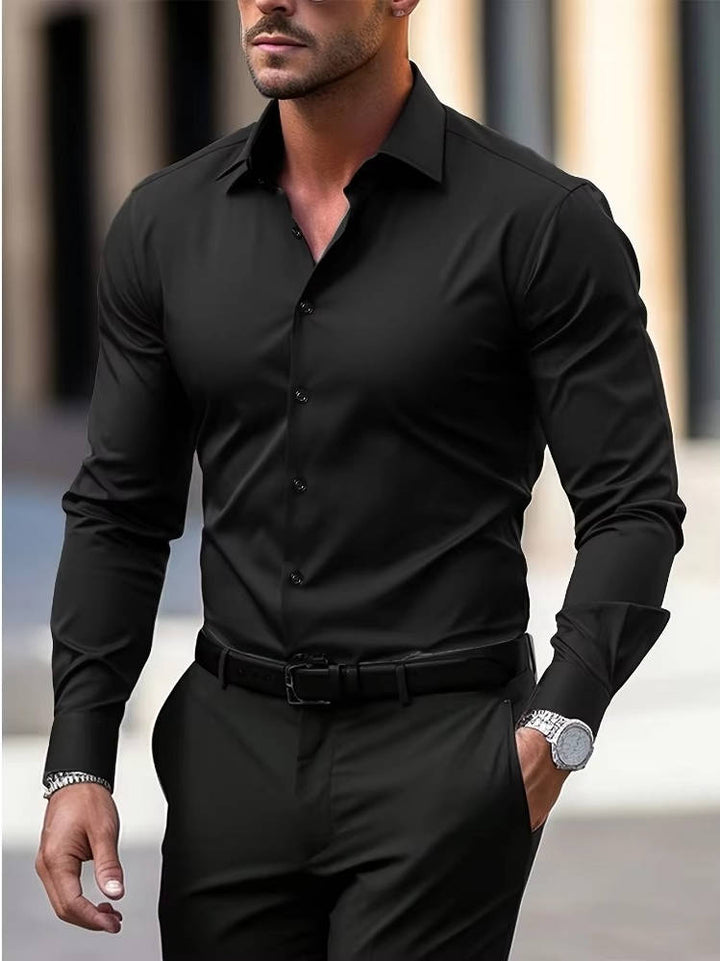 Homme en chemise noire assortie à un pantalon noir, vue de trois quarts, une main en poche 3
