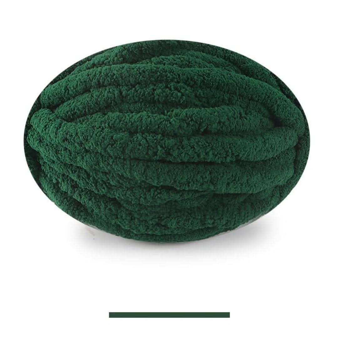 Pelote ovale de fil épais et moelleux vert foncé, sur fond blanc, avec un échantillon de la teinte en dessous. 14