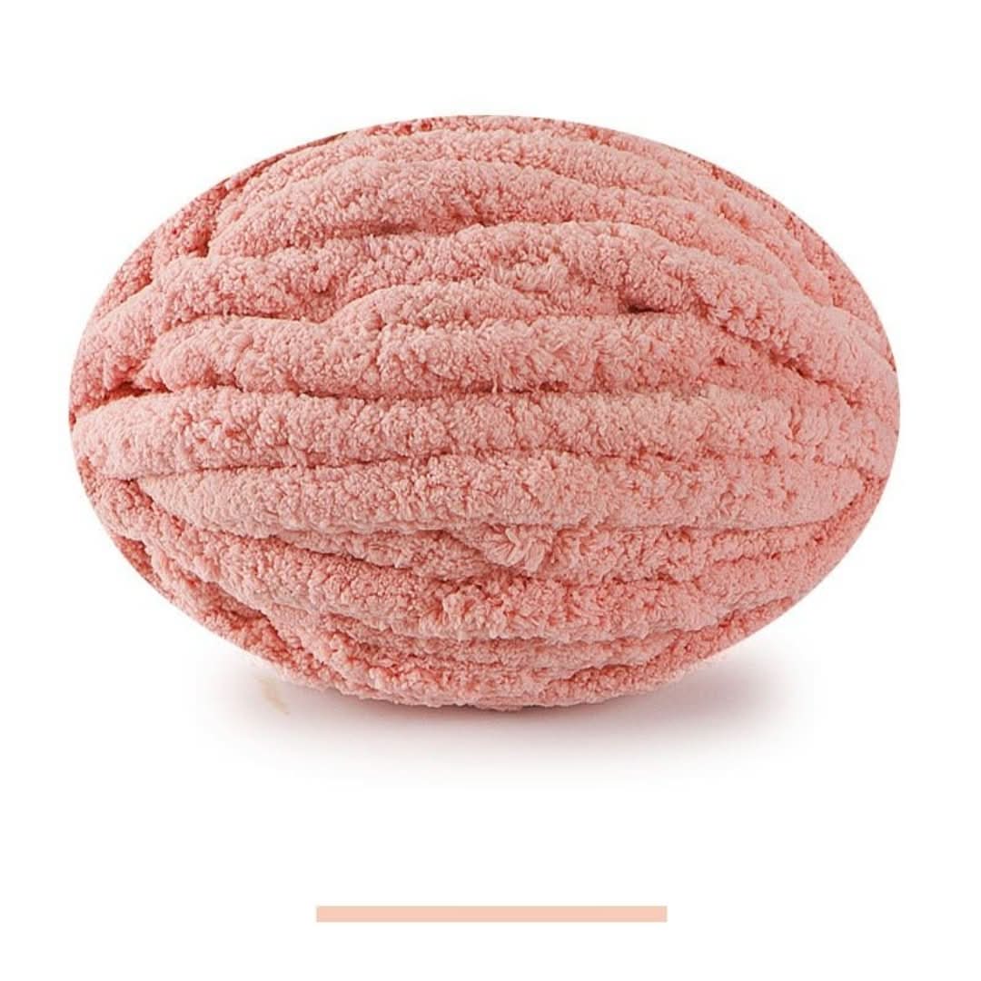Pelote ovale de fil épais et moelleux rose saumon, sur fond blanc, avec un échantillon de la teinte en dessous. 13