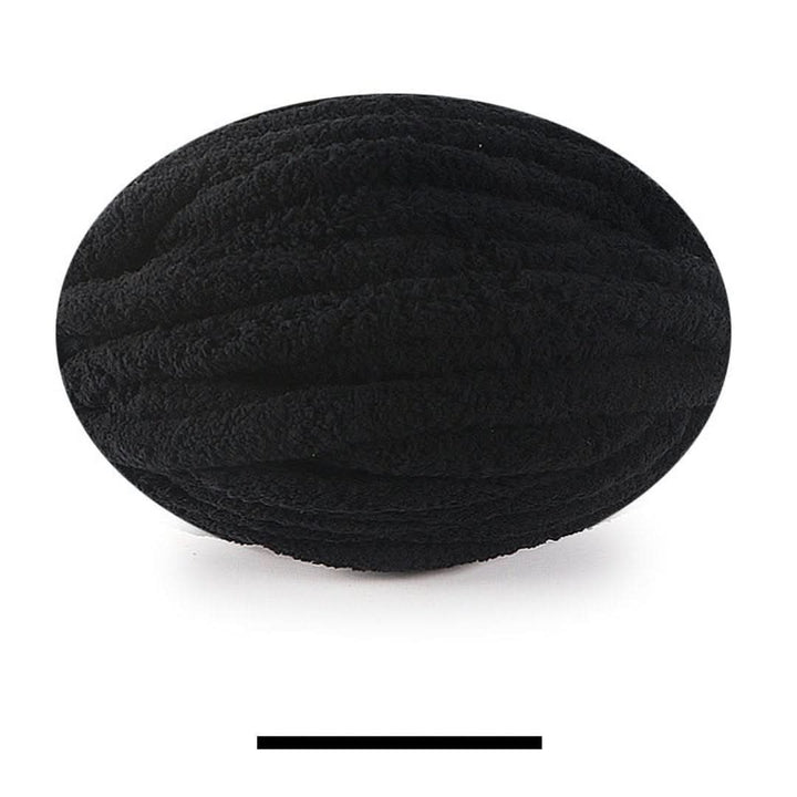 Pelote ovale de fil épais et moelleux noir, sur fond blanc, avec un échantillon de la teinte en dessous. 20