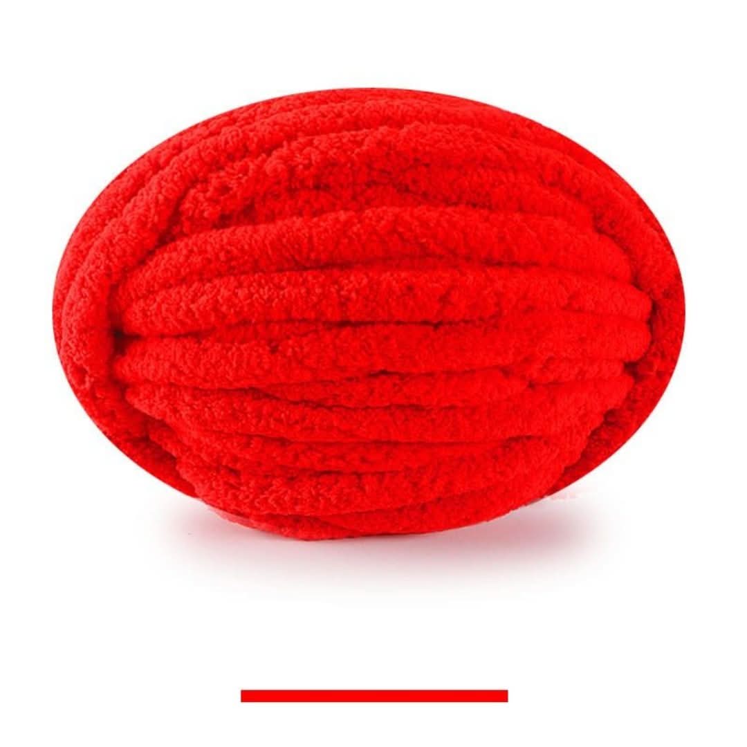 Pelote ovale de fil épais et moelleux rouge vif, sur fond blanc, avec un échantillon de la teinte en dessous. 17