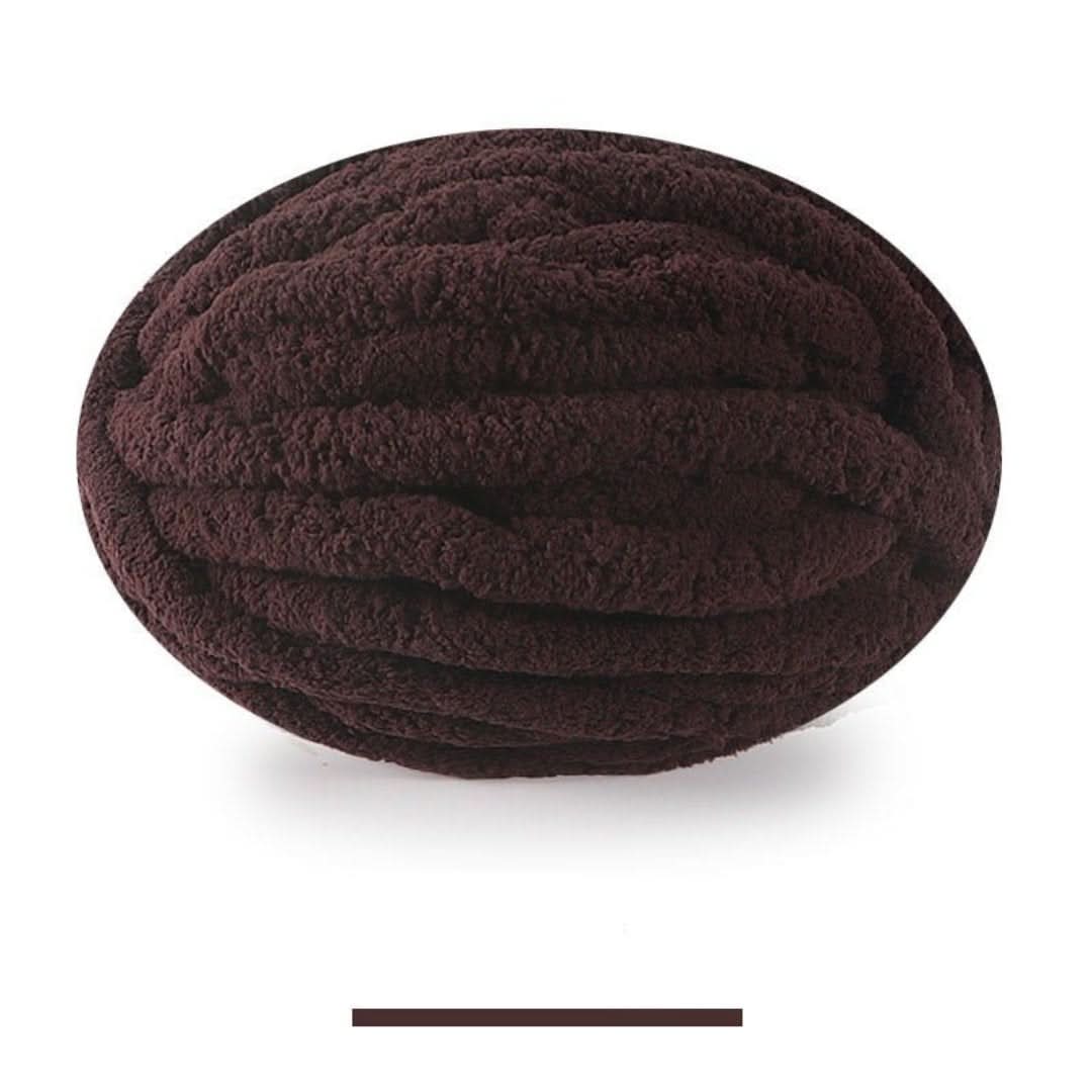 Pelote ovale de fil épais et moelleux marron foncé, sur fond blanc, avec un échantillon de la teinte en dessous. 6