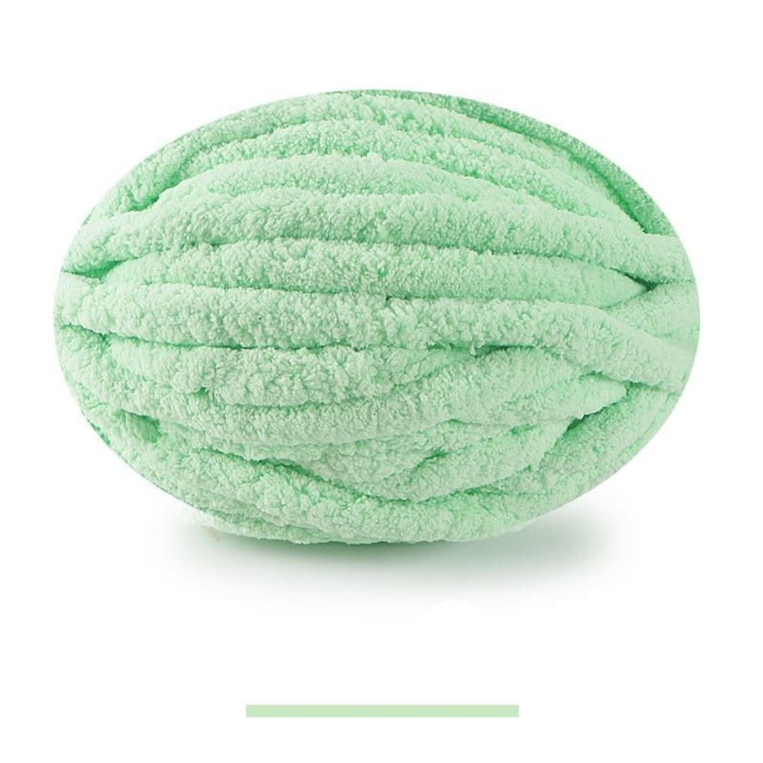 Pelote ovale de fil épais et moelleux vert menthe, sur fond blanc, avec un échantillon de la teinte en dessous. 5