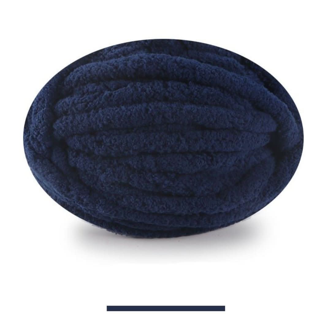 Pelote ovale de fil chenille épais en bleu marine foncé, aux boucles douillettes bien visibles, avec sa barre de coloris. 23