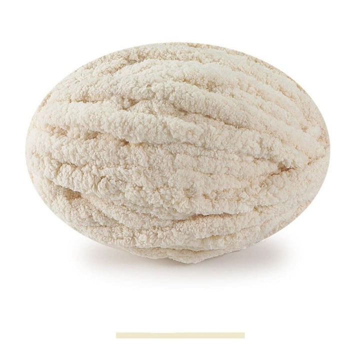 Pelote ovale de fil épais et moelleux beige clair, sur fond blanc, avec un échantillon de la teinte en dessous. 9