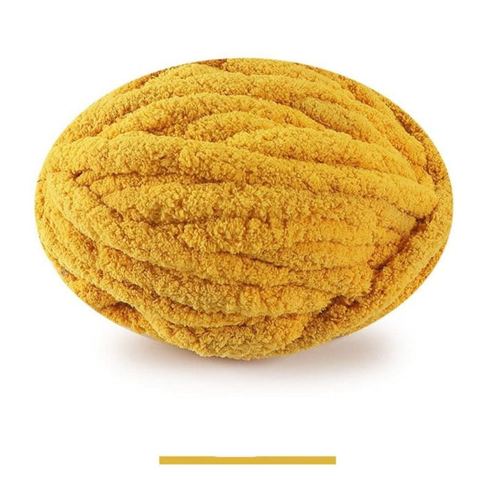 Pelote ovale de fil épais et moelleux jaune moutarde, sur fond blanc, avec un échantillon de la teinte en dessous. 12