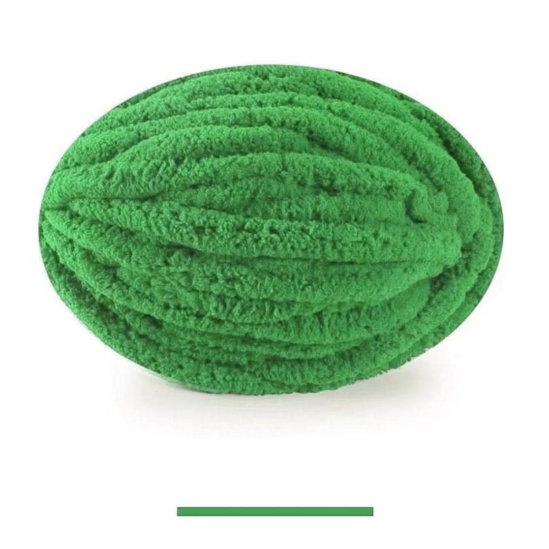 Pelote ovale de fil épais et moelleux vert franc, sur fond blanc, avec un échantillon de la teinte en dessous. 19