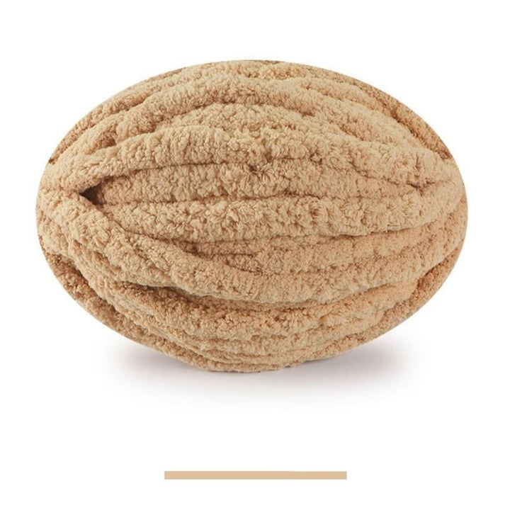 Pelote ovale de fil épais et moelleux beige doré, sur fond blanc, avec un échantillon de la teinte en dessous. 10