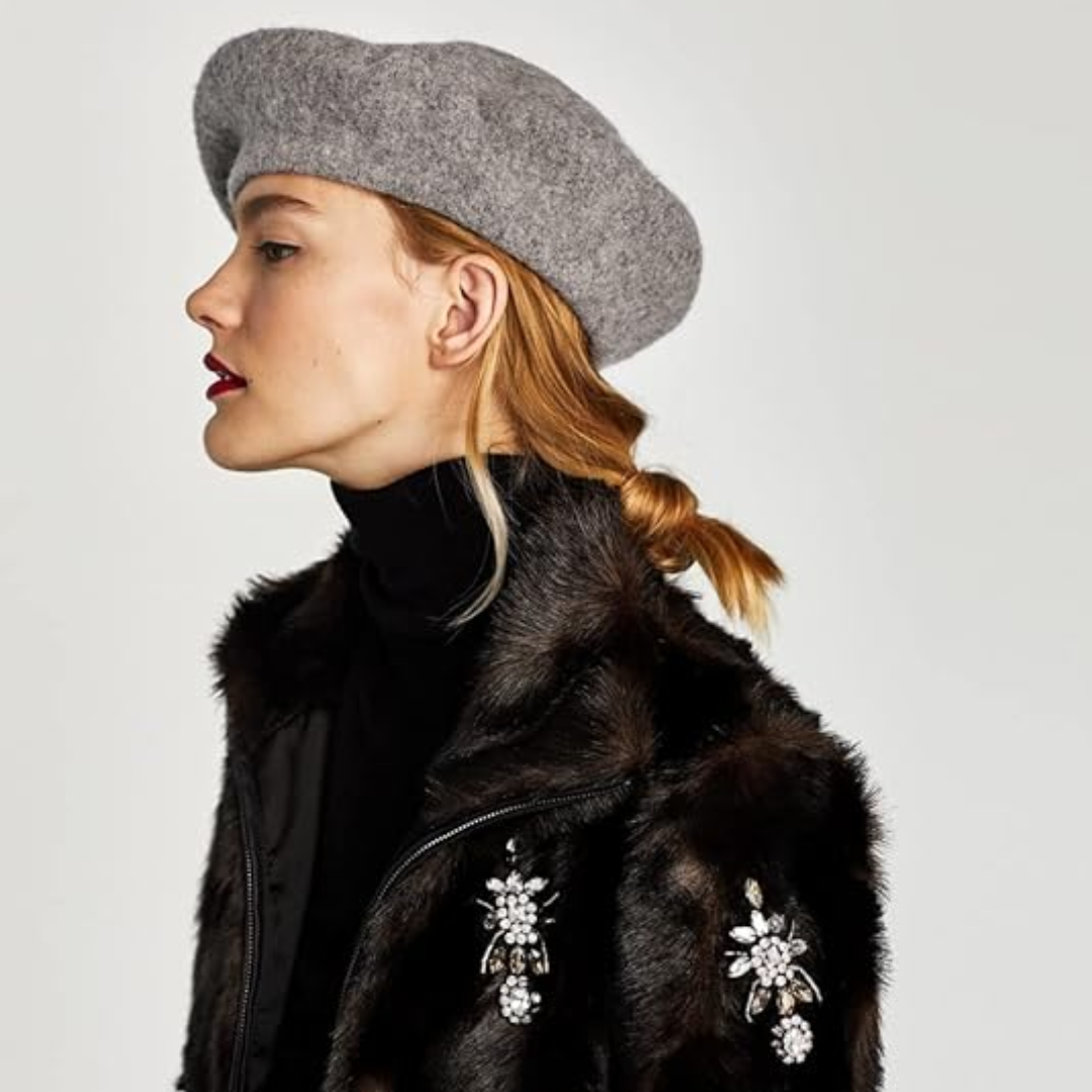 Béret gris chiné porté par une femme de profil, avec un manteau de fourrure orné de bijoux 23