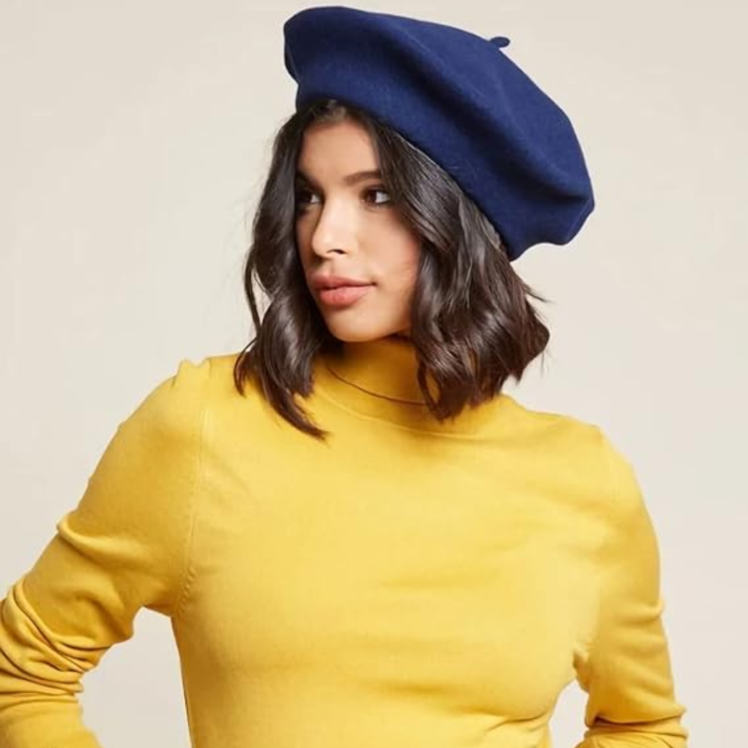 Femme brune portant un béret bleu marine, pull jaune à col roulé, tournée de profil 17