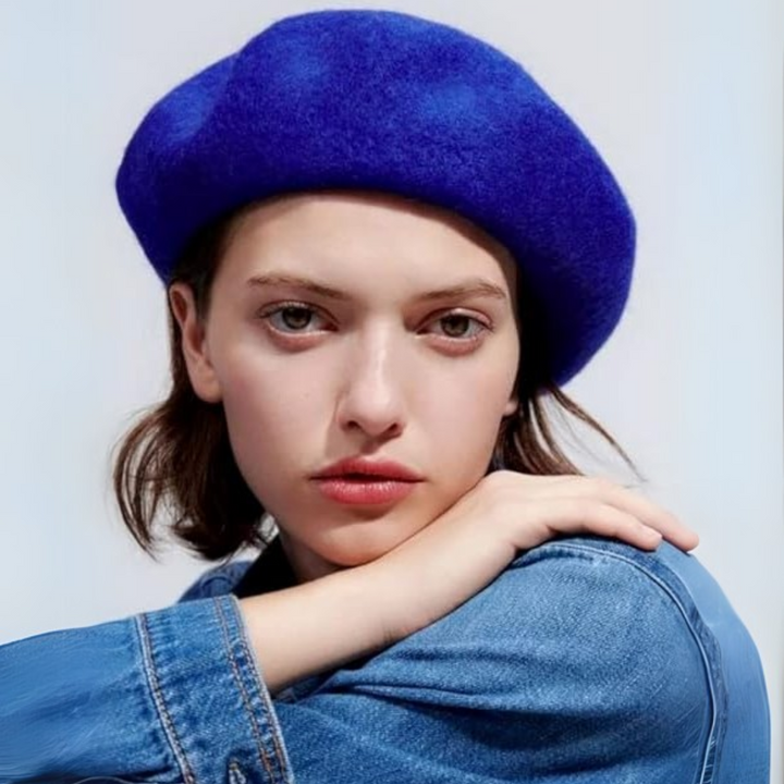 Jeune femme portant un béret bleu roi et une veste en jean, main posée sur l'épaule 19