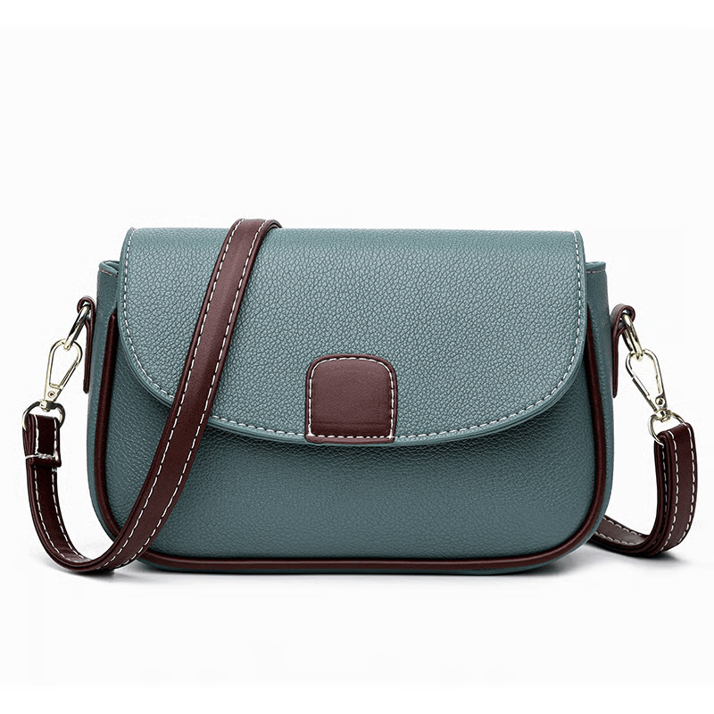 Sac bleu-vert vu de face sur fond blanc, avec bandoulière bordeaux surpiquée et rabat arrondi 8
