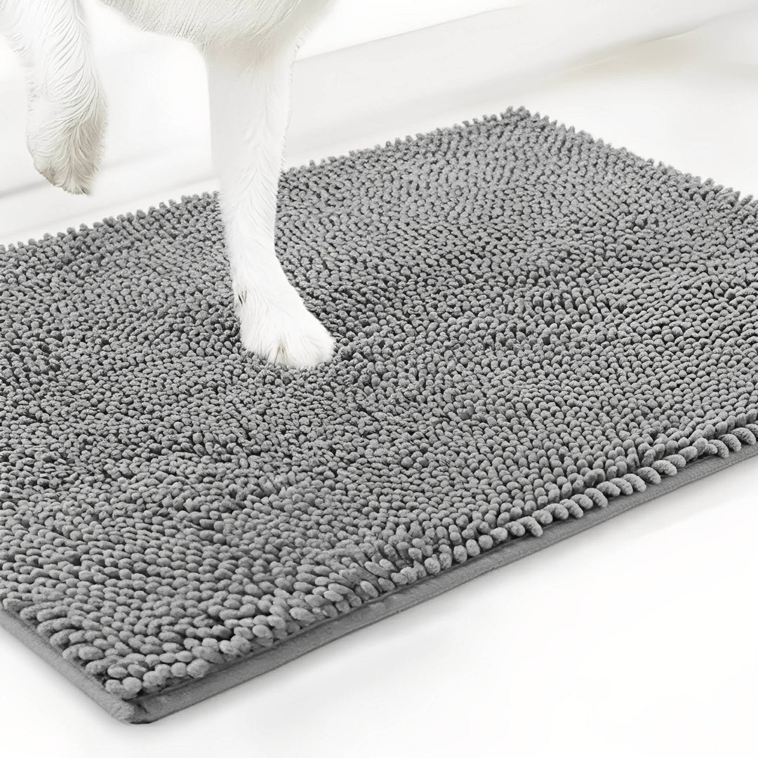 Patte blanche de chien posée sur le tapis en chenille gris clair, vue d'angle sur fond blanc. 12