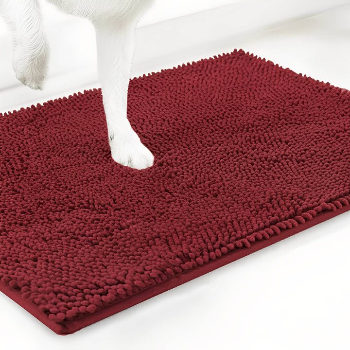Tapis en chenille rouge bordeaux avec une patte de chien blanche posée dessus, sur fond blanc. 14