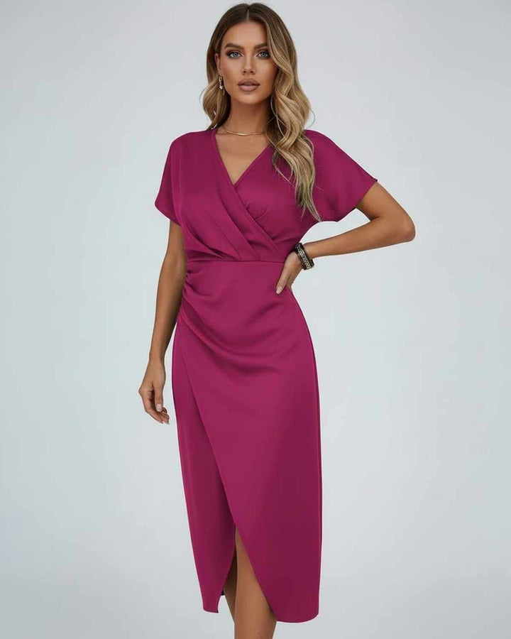 Robe fuchsia portée par une femme, une main sur la hanche, col en V et fente 1