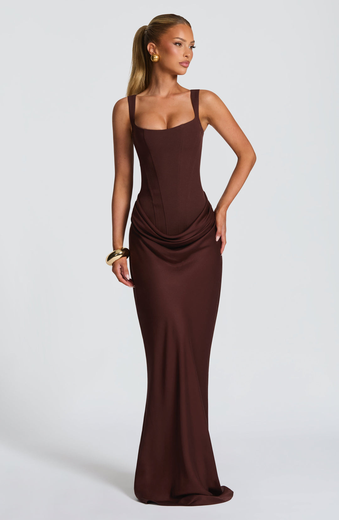 Robe longue marron portée de face, bras le long du corps, corset ajusté et jupe évasée en bas. 6