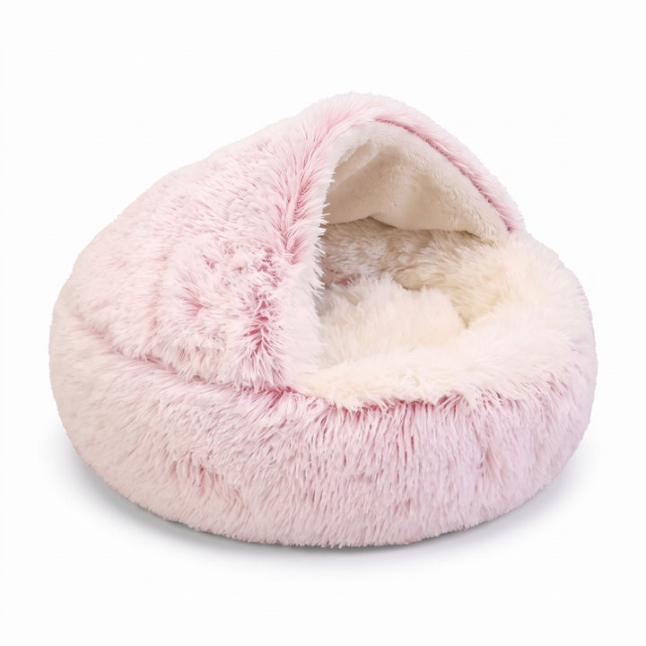 Panier-cave rond en peluche rose pâle sur fond blanc, capuche entrouverte sur un intérieur crème, vue de trois quarts. 15