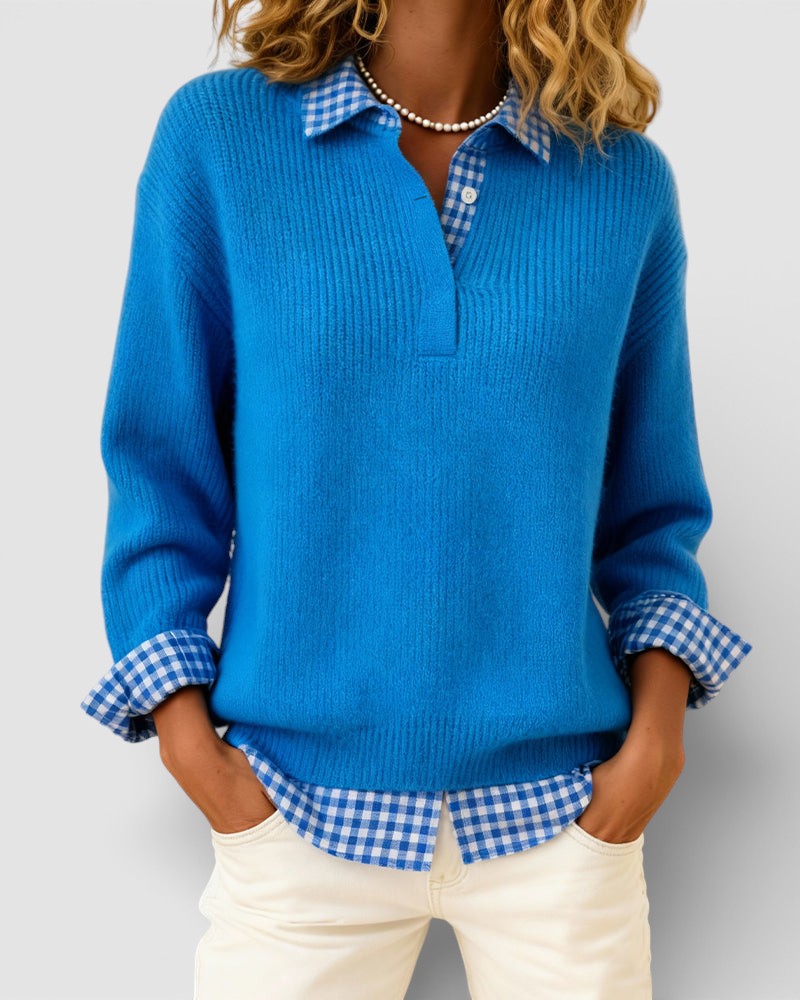 Pull bleu en maille côtelée porté par un mannequin, mains dans les poches, avec col et manchettes vichy bleu et blanc visibles. 1