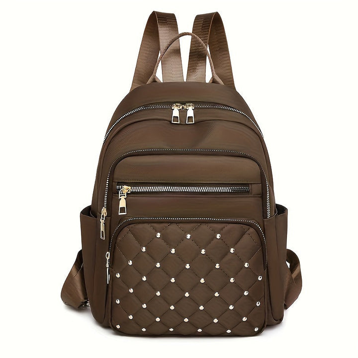Sac à dos marron foncé vu de face, poche avant matelassée avec clous dorés 15