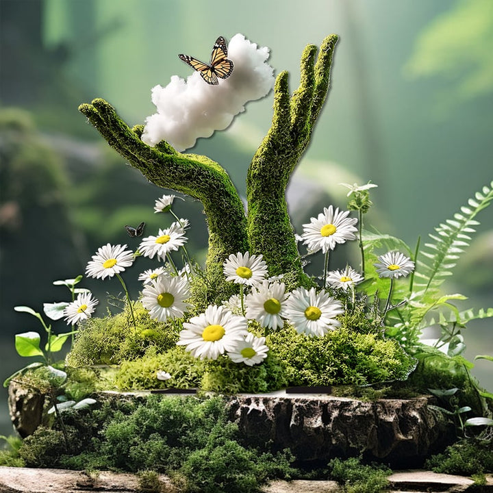 Deux mains moussues dressées vers un nuage blanc où se pose un papillon, entourées de marguerites et de fougères sur un rocher. 22