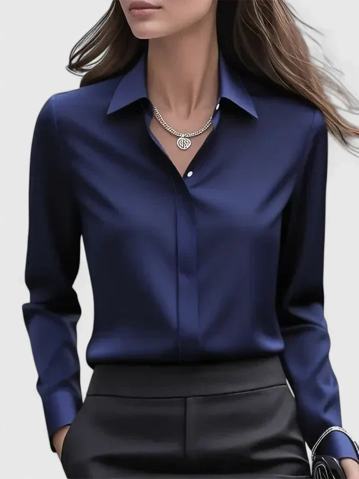 Vue de face du chemisier bleu marine satiné porté avec un pantalon noir, collier argenté et boutons discrets. 1