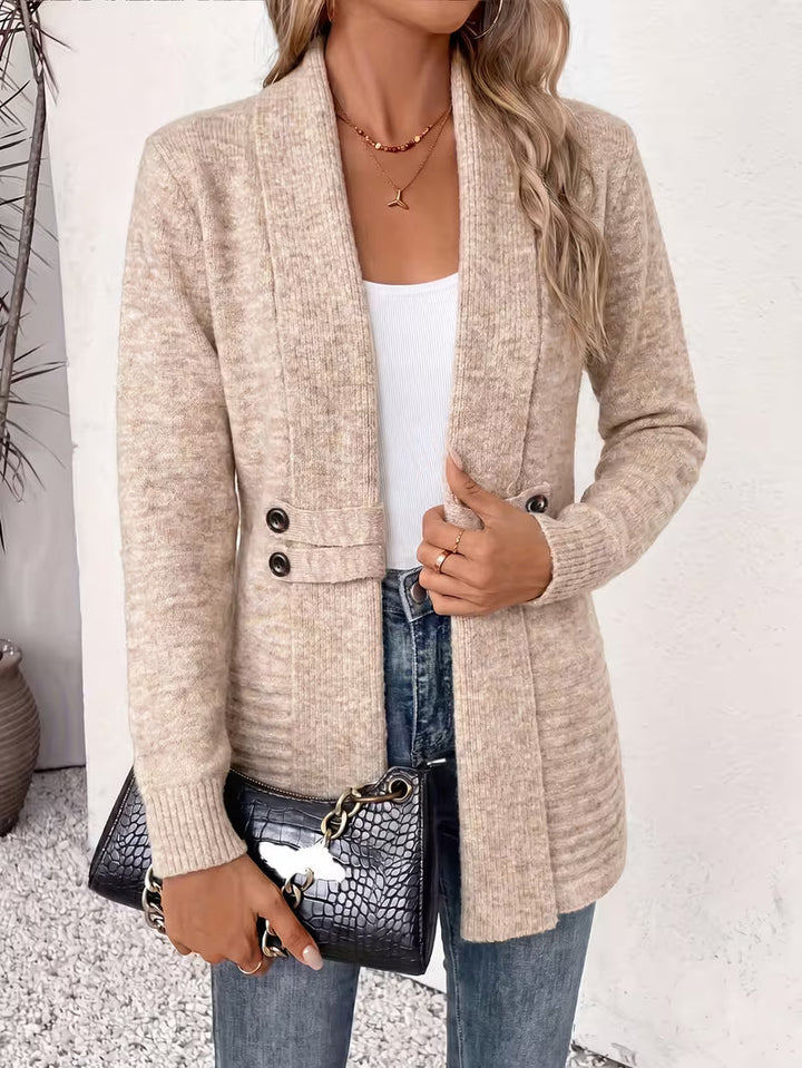 Cardigan beige porté avec un sac noir effet croco, vue de face près d'un mur blanc 3