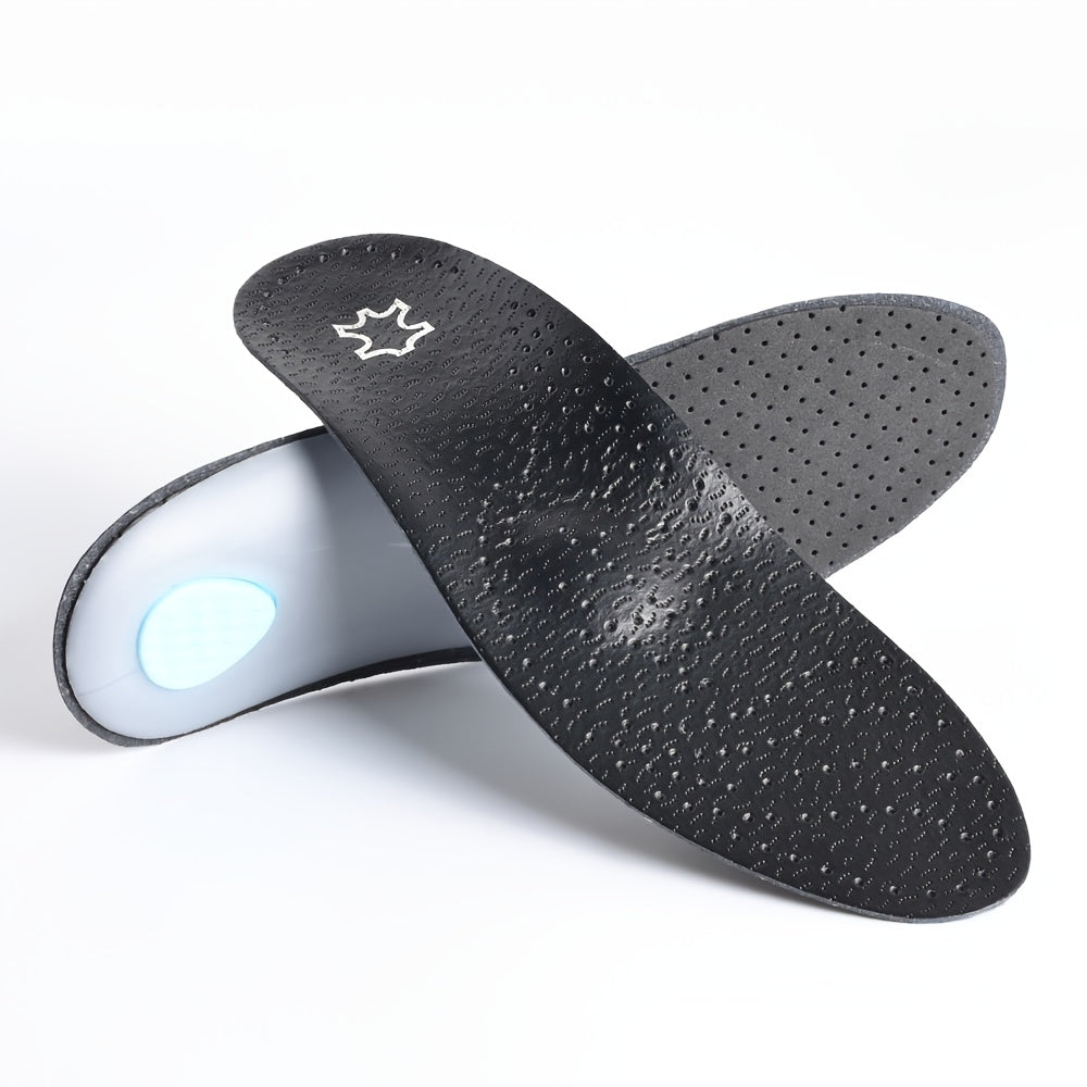 Deux semelles noires perforées croisées, l'une montrant le dessus texturé, l'autre la face inférieure grise avec coque d'appui et coussinet bleu au talon. 1