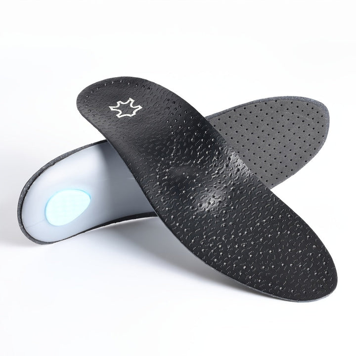Paire de semelles noires croisées sur fond blanc, le dessus perforé au premier plan et la coque grise avec coussinet bleu visible derrière. 6