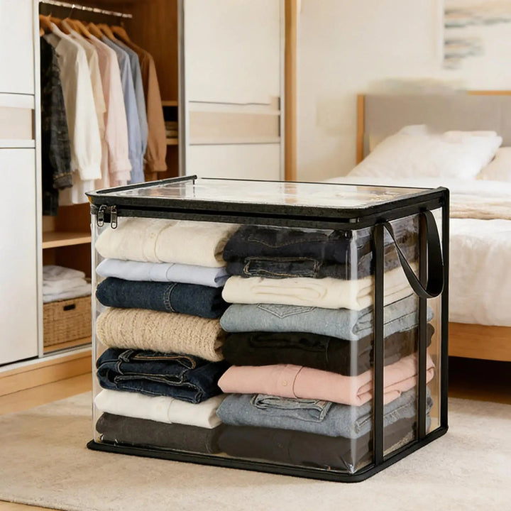 Bac transparent bordé de noir rempli de vêtements pliés, posé au sol dans une chambre près d'un dressing et d'un lit. 1