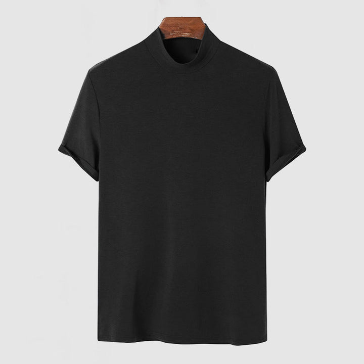 Tee noir à col montant et manches courtes retroussées, présenté de face sur un cintre en bois. 5