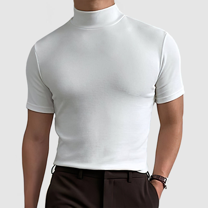 Homme en tee blanc à col montant et manches courtes, vu de face, avec pantalon marron foncé et montre. 8