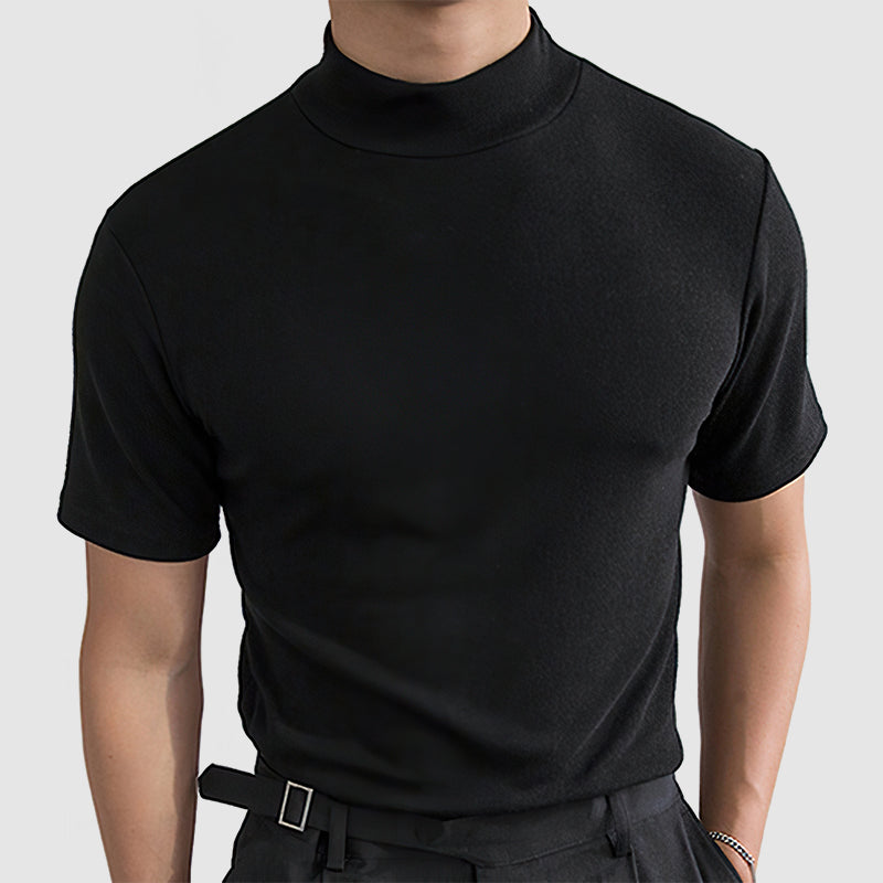 Même tee noir à col montant porté de face, coupe ajustée sur le buste, avec ceinture à boucle carrée. 4