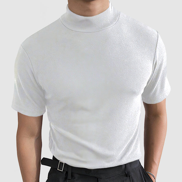 Homme portant le tee blanc à col montant et manches courtes, vu de face, avec pantalon noir et bracelet au poignet. 2